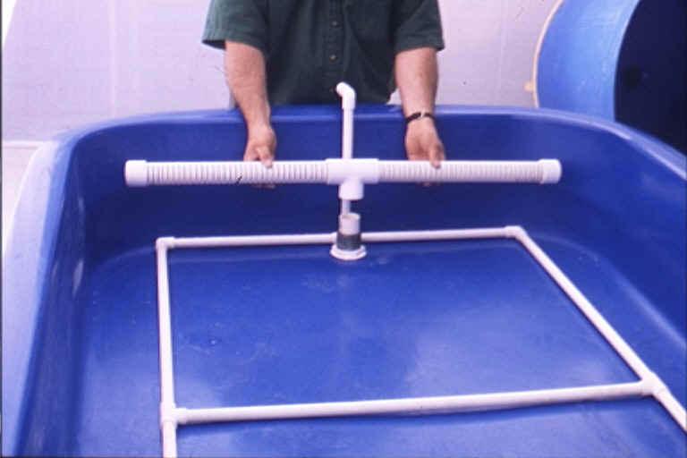 a) The Air Ring arrives pre-assembled: just place it in the Aquaponic Tray with the vertical section of pipe located between the wall of the Tray and the Inflow Bulkhead Assembly.
