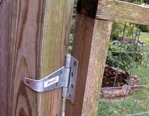 The wooden gate is attached to the wood post with a simple door hinge. A slide lock was also added to help keep the fence shut. A bike lock can also be used to keep the gate firmly shut.