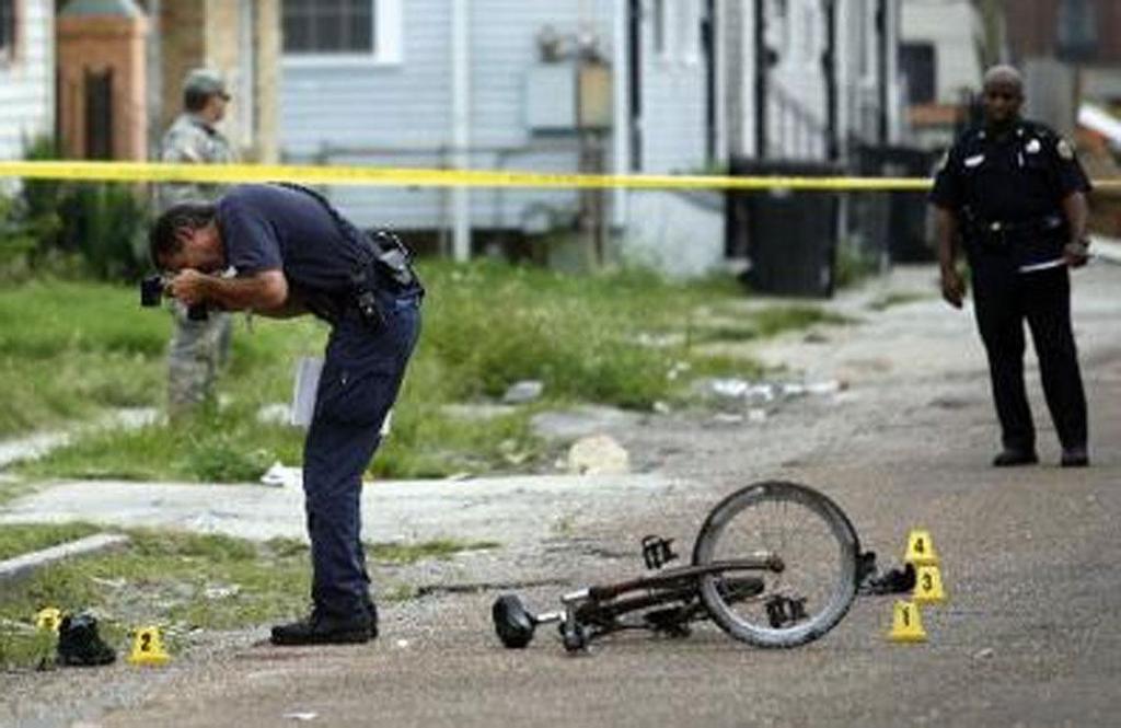 FIGURE 11.6 Then crime scene investigator Eddie-Joe Delery, of the NOPD crime lab, is shown photographing a spent.40 caliber shell casing at the scene of a shooting in June, 2007.