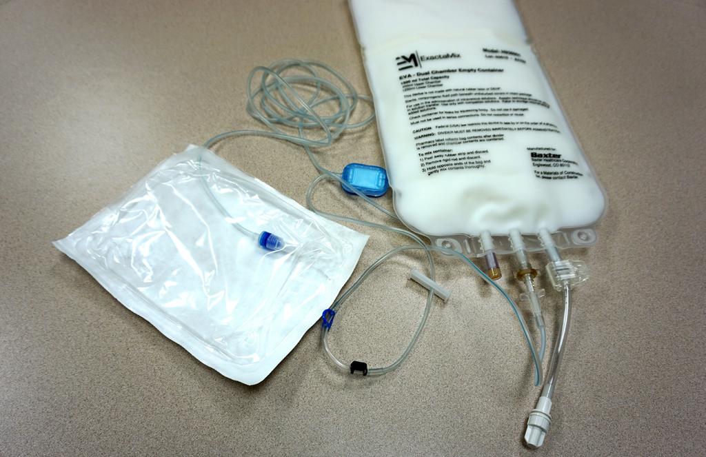 4. While holding the port on your IV bag with your non-dominant hand, insert the