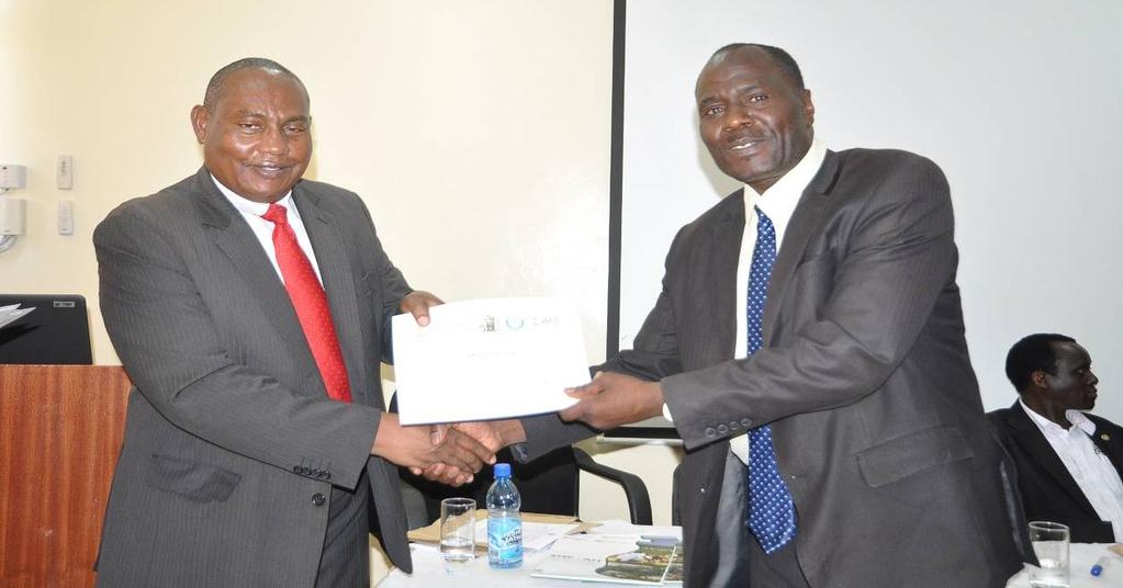 Dr. David Ojigo being presented with a certificate of facilitation of the workshop