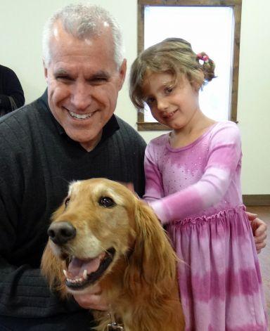 Michael Ross, managing director of the Westport Country Playhouse, and Kathryn Iacono, 4, say hello to Meca, a therapy dog, at the theater Sunday.